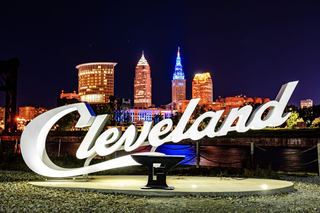 The Cleveland skyline at night with the Cleveland script sign